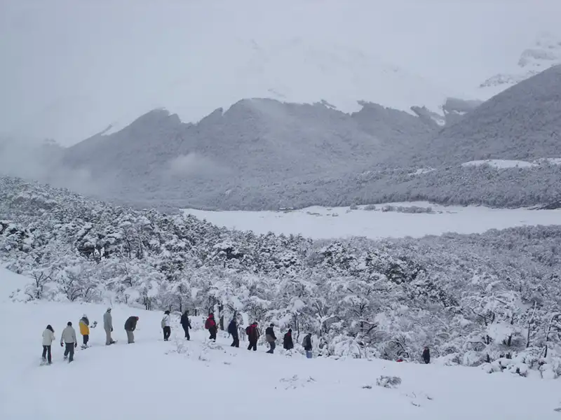 Grupo de trekkers en Laguna Esmeralda Ushuaia con el Glaciar Ojo del Albino al fondo